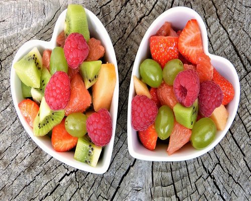 fresh healthy salad and fruits on colorful table